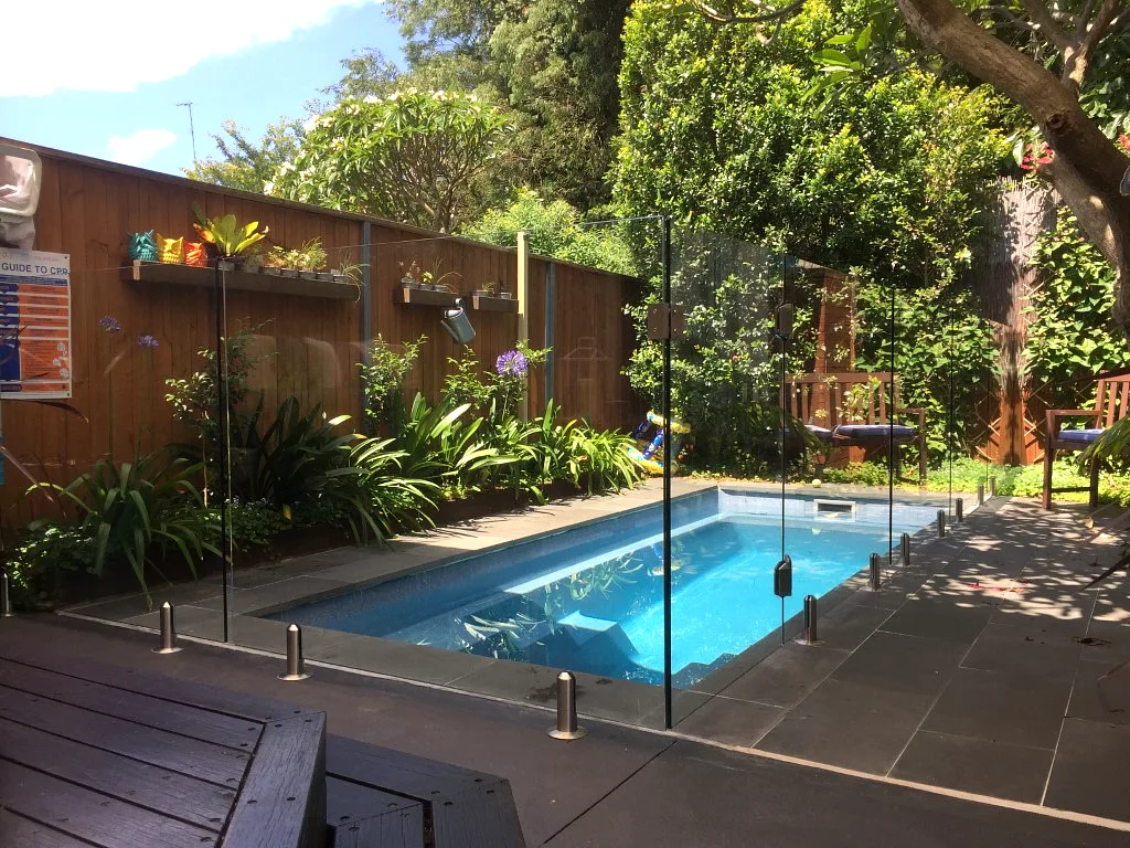 Residential pool enclosed with clear glass fencing